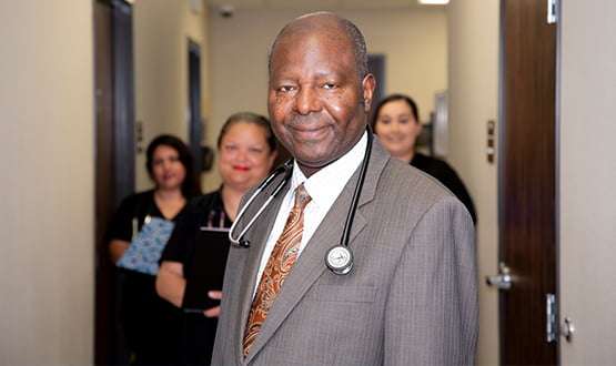 Family doctor Dr. Oloyo standing in the hallway with staff