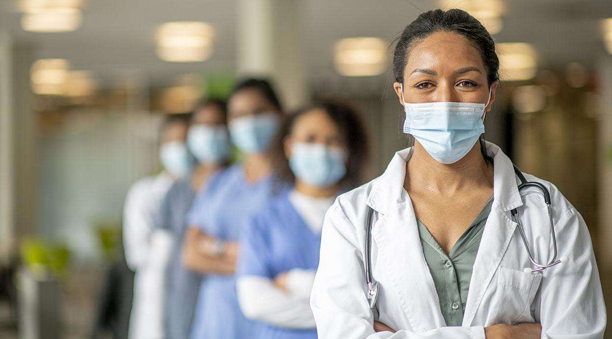 A group of women in surgical masks, possibly primary care physicians, standing in a hallway in Corpus Christi, Texas.