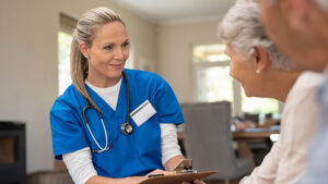 friendly nurse talking to elderly couple about preventative healthcare