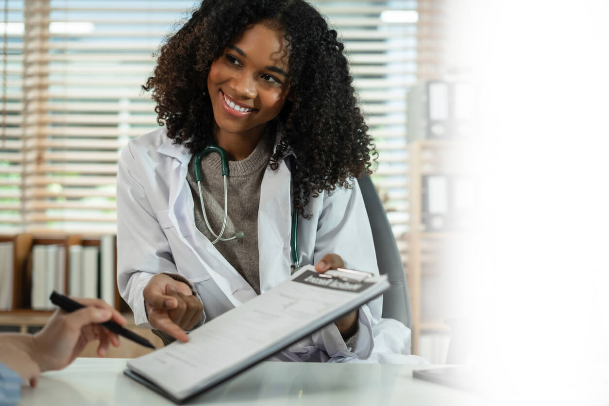 Patient filling insurance legal document at appointment with doctor.